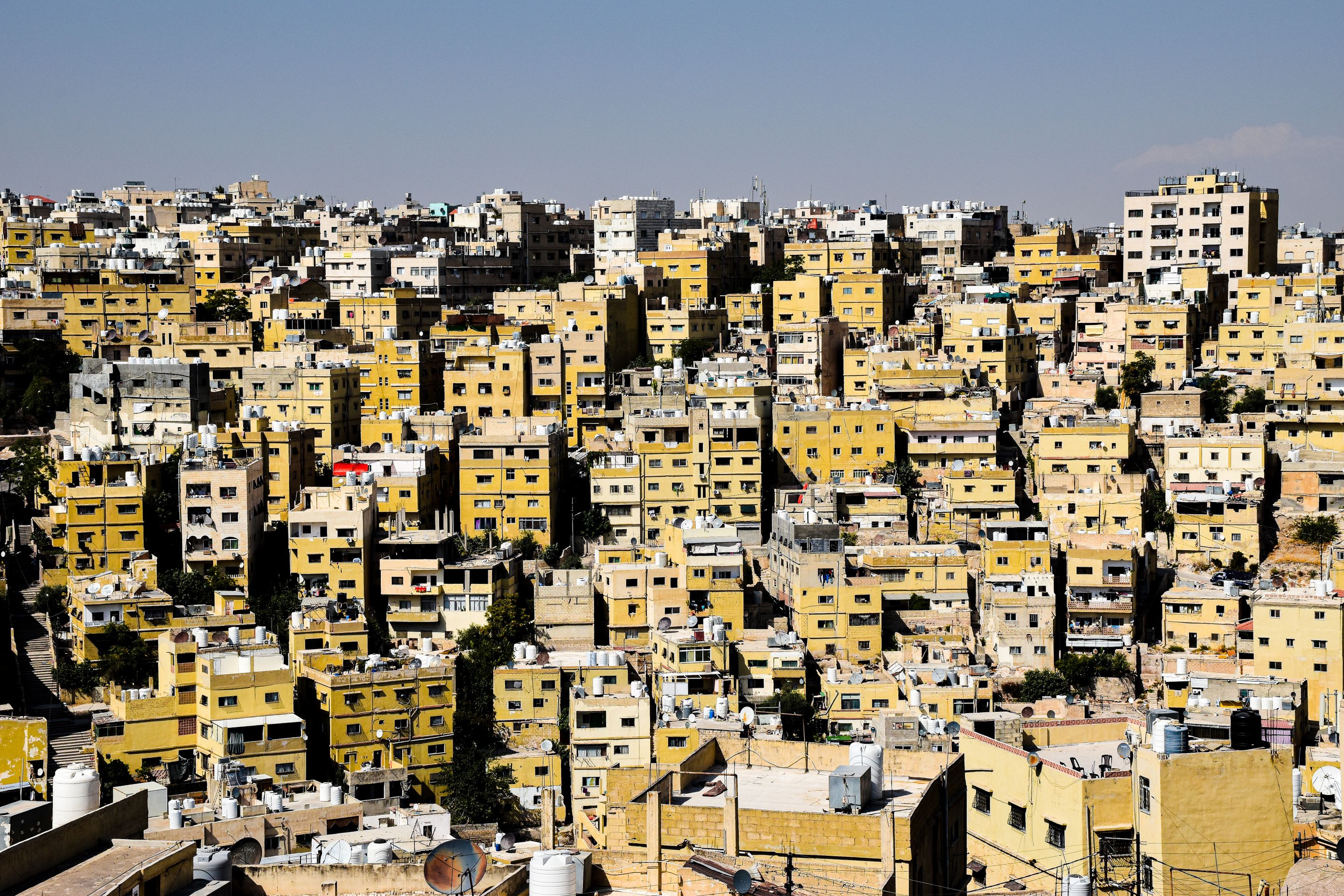 Aerial view capturing the densely packed urban buildings in Amman, Jordan, depicting a bustling cityscape.