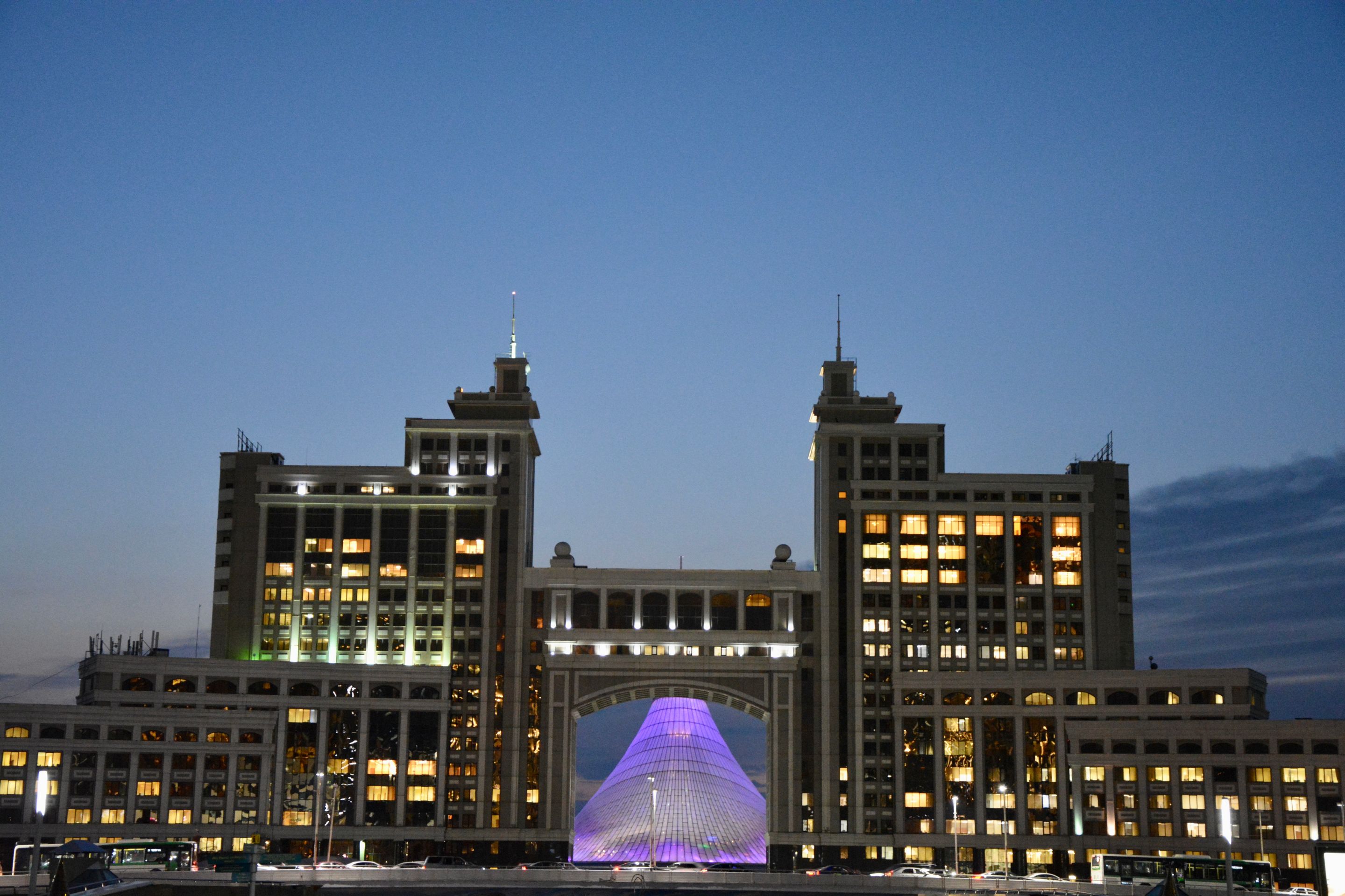 Majestic view of Astana's iconic architecture glowing against evening sky.