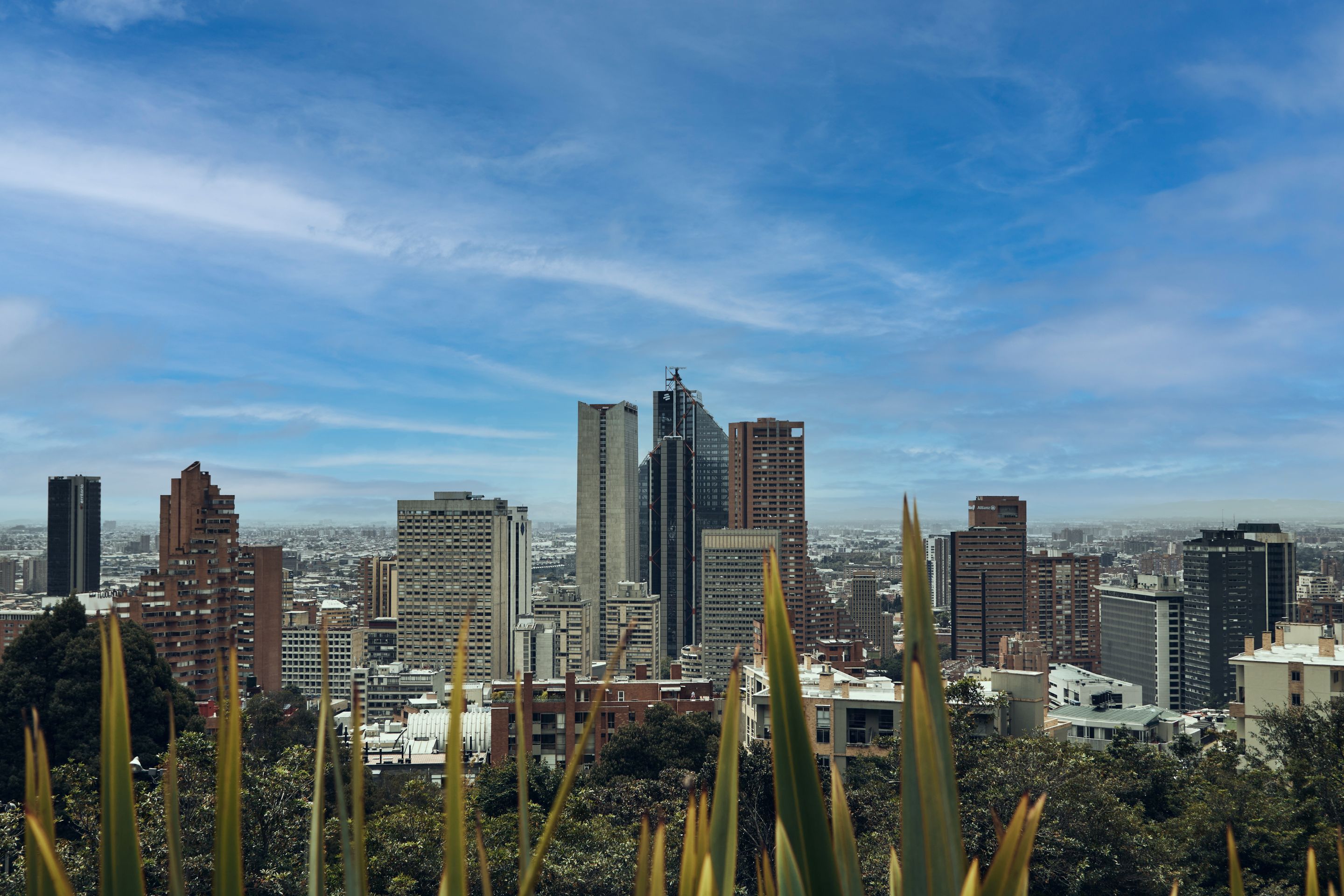 A picturesque view of Bogotá's skyline featuring modern skyscrapers against a bright blue sky.