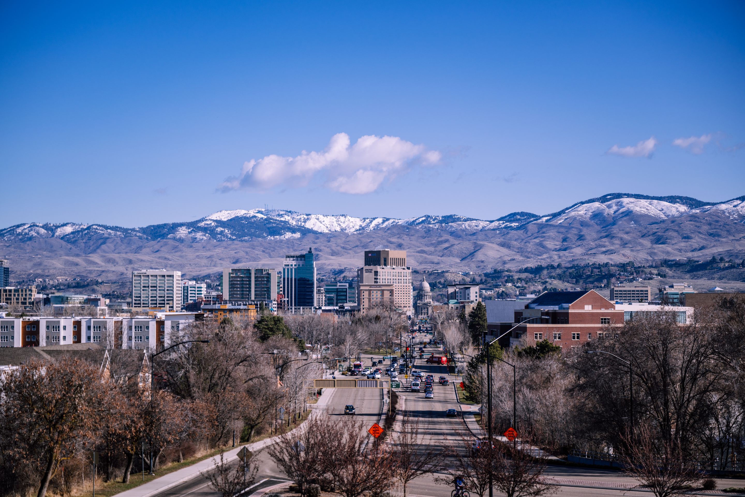 A stunning view of downtown Boise, Idaho, featuring mountains and clear blue skies.