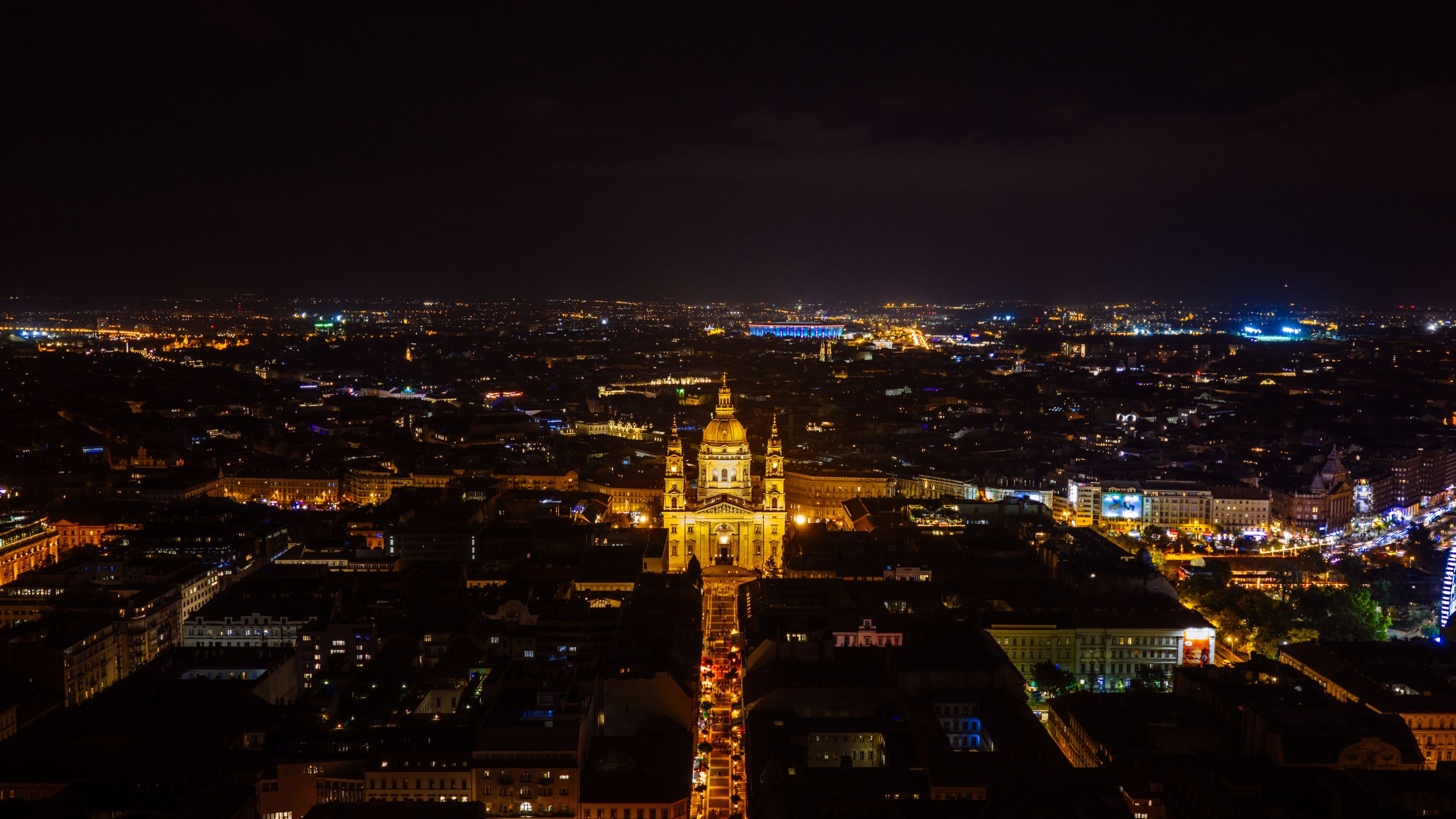 A captivating aerial view of Budapest at night featuring St. Stephen's Basilica illuminated.