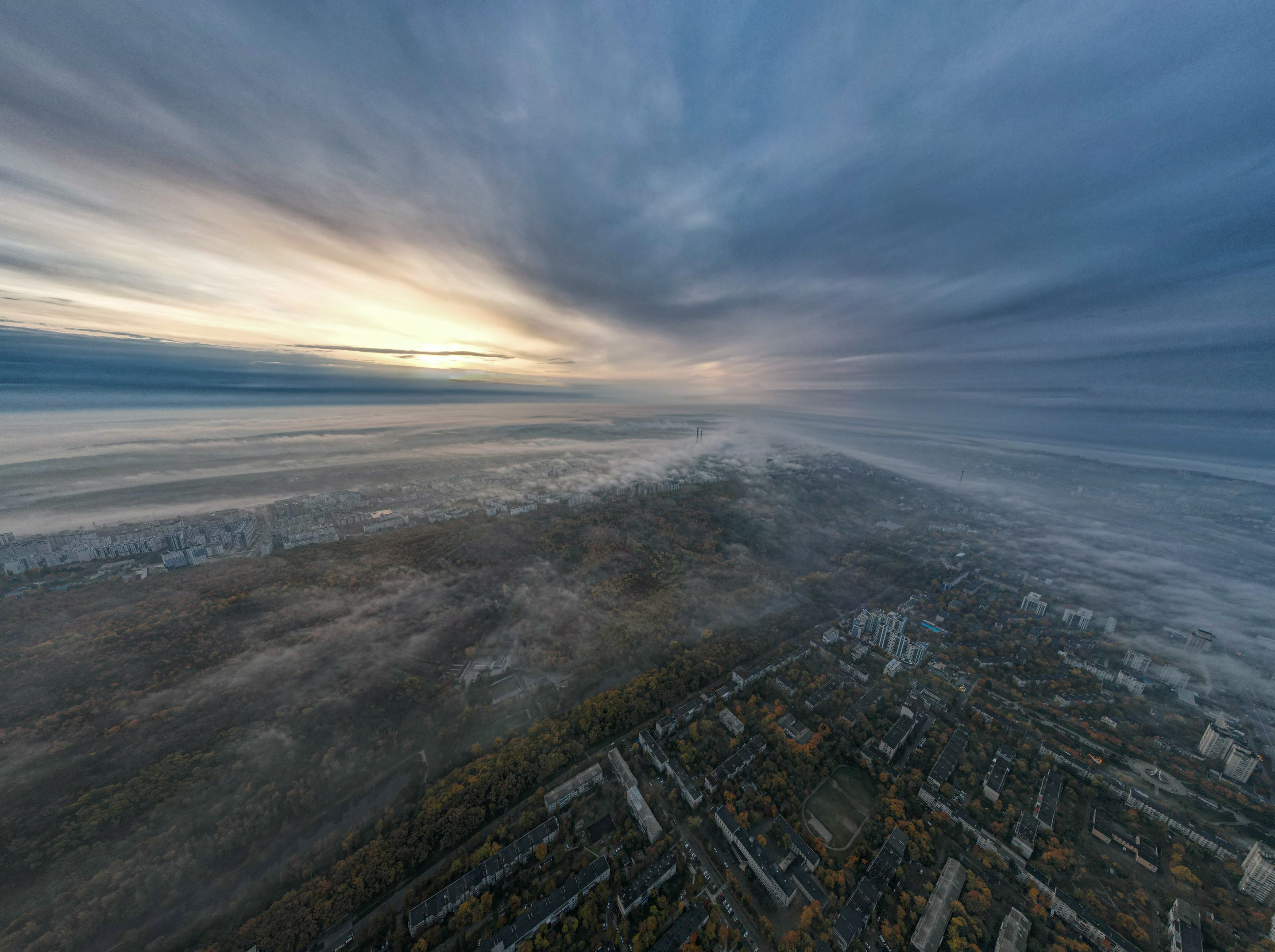 Breathtaking aerial view of Chișinău, Moldova at sunrise. Cityscape shrouded in mist and clouds.
