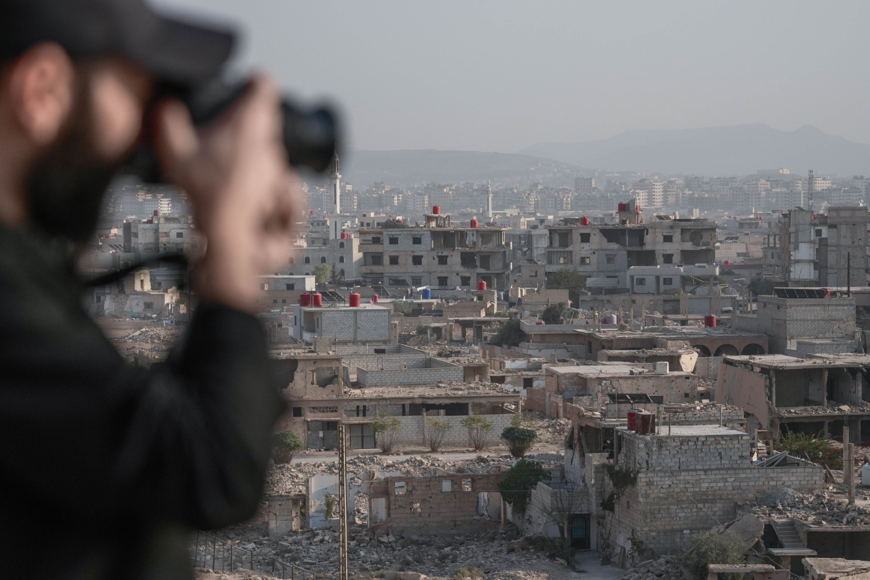 Blurred photographer captures cityscape of Damascus with historical architecture in focus.