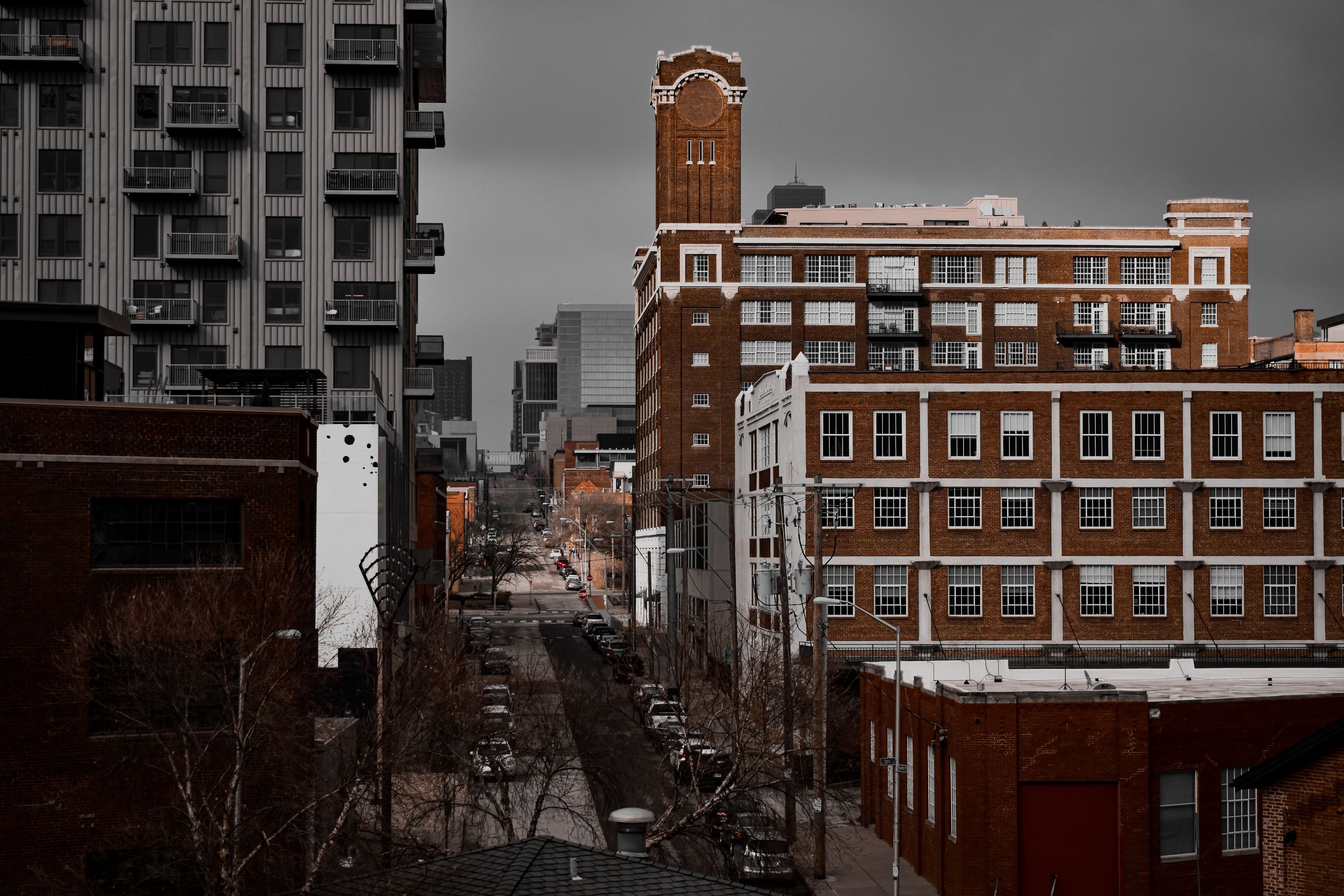 Explore the dense urban landscape of Kansas City, featuring historic brick architecture and modern apartment buildings on a cloudy day.