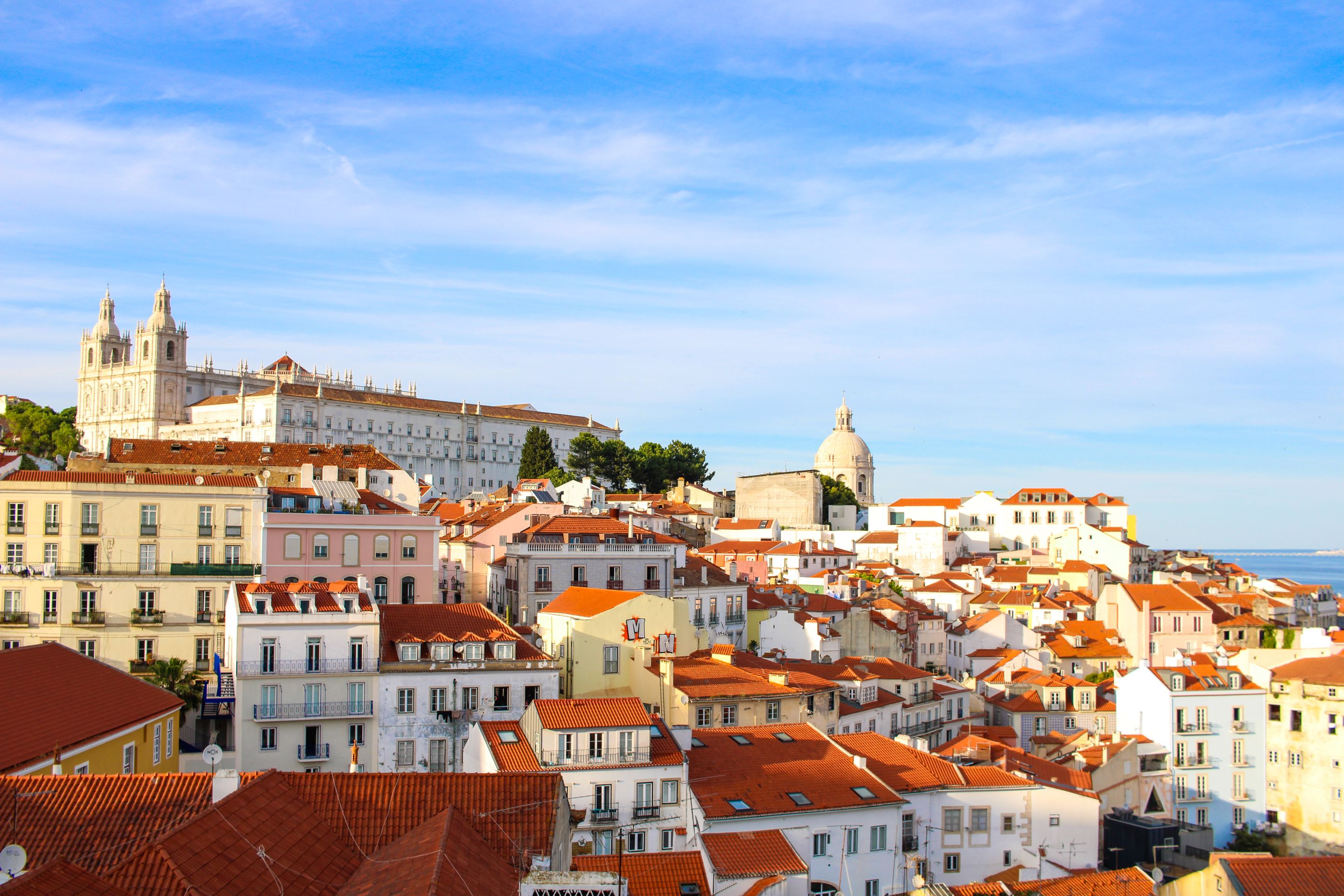 A scenic view over Lisbon's historic Alfama district showcasing traditional architecture under a clear sky.