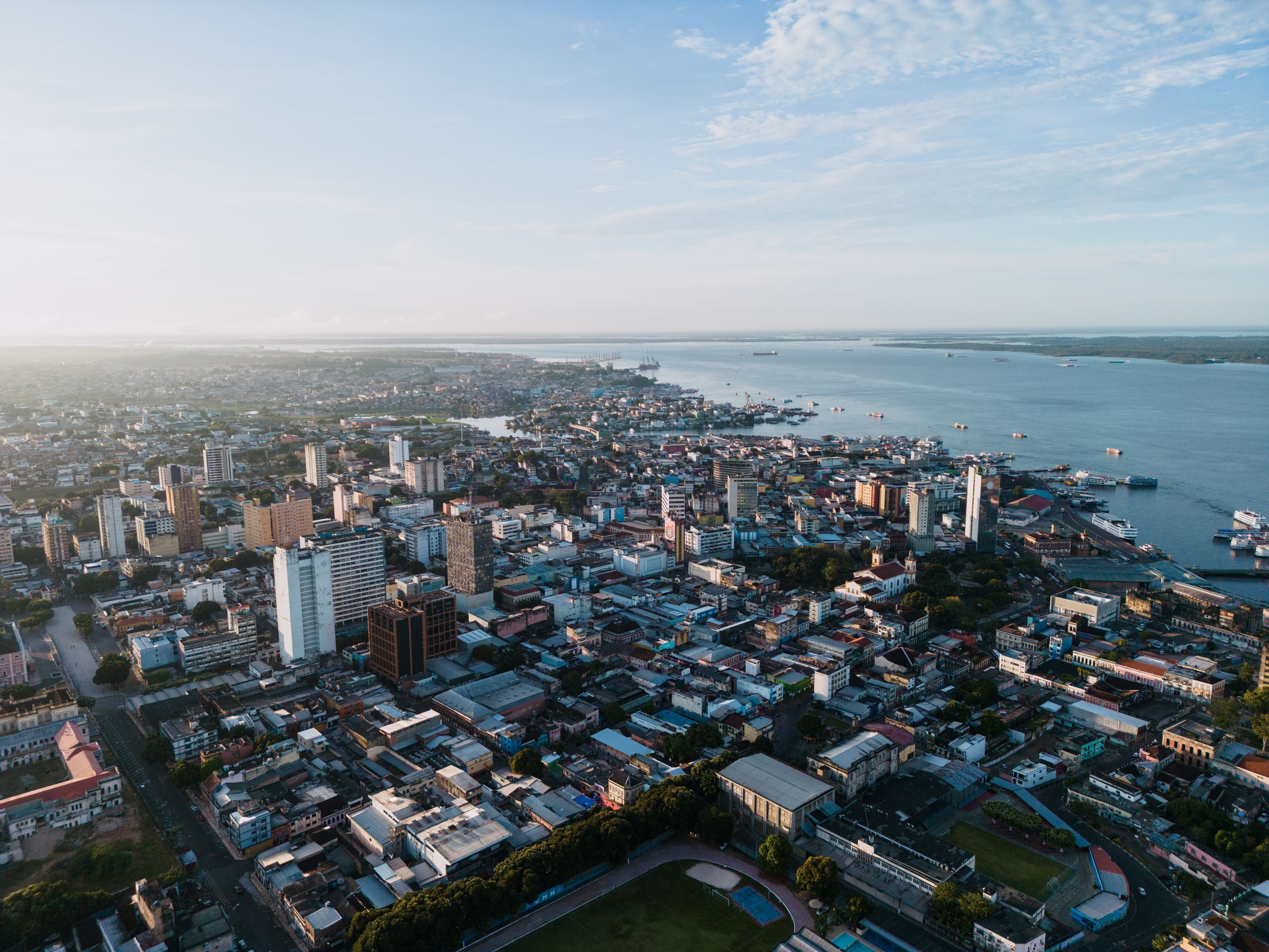 Breathtaking aerial view of Manaus cityscape with Rio Negro at sunset. Perfect for urban and travel themes.