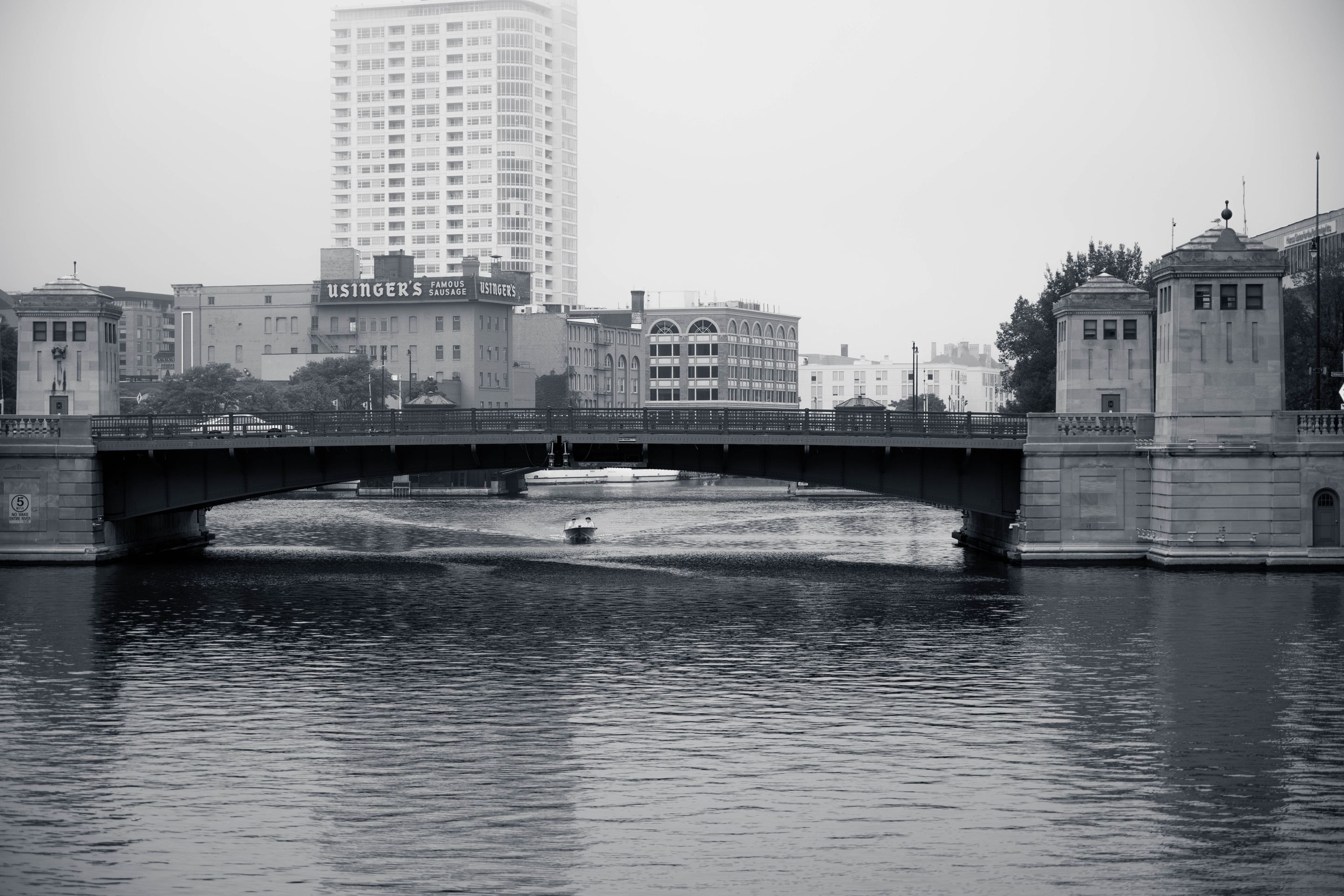 Scenic black and white view of Milwaukee's urban landscape featuring a prominent bridge and waterways.
