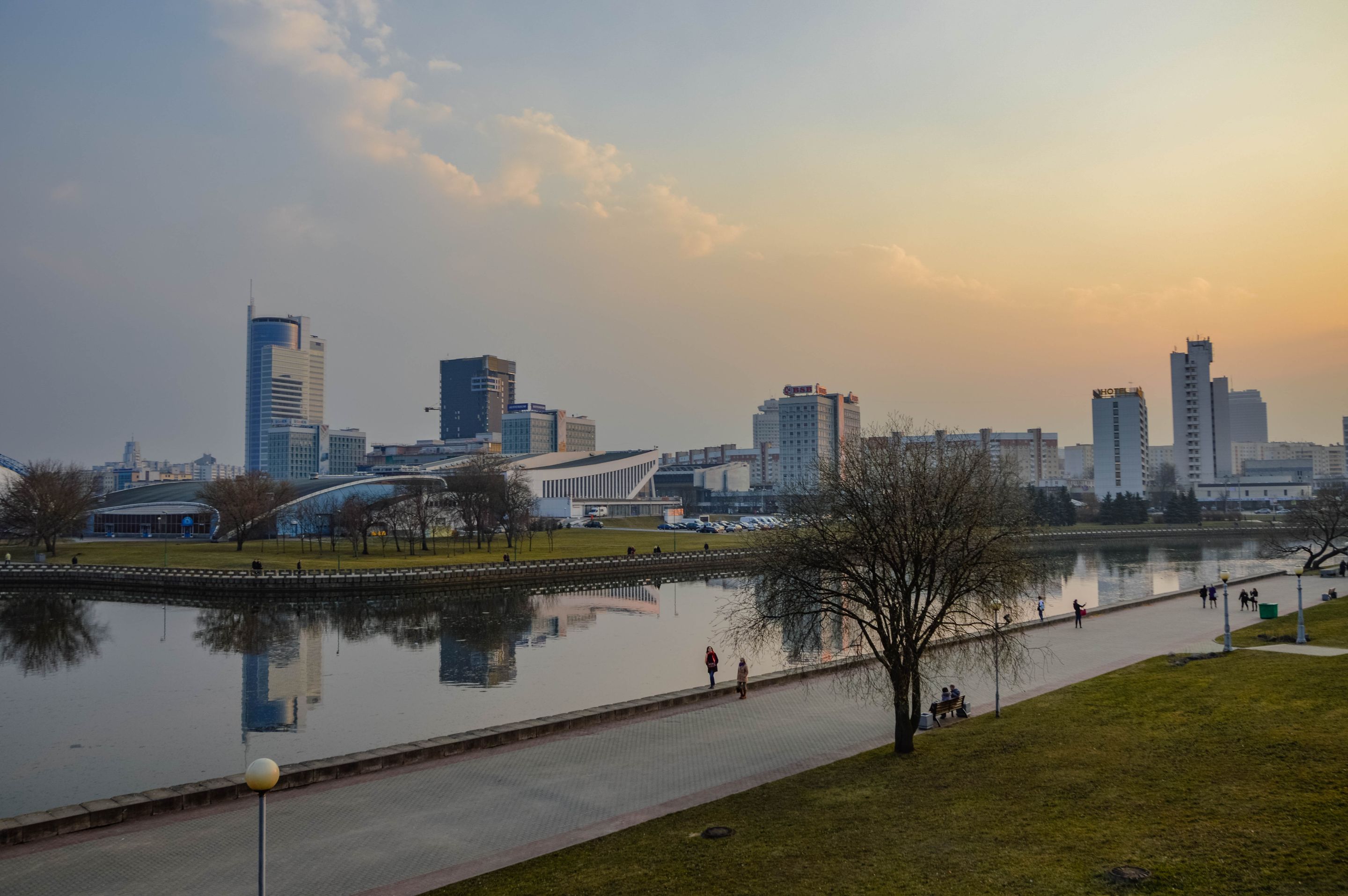 A stunning city skyline reflects in a river during sunset, capturing urban tranquility and beauty.