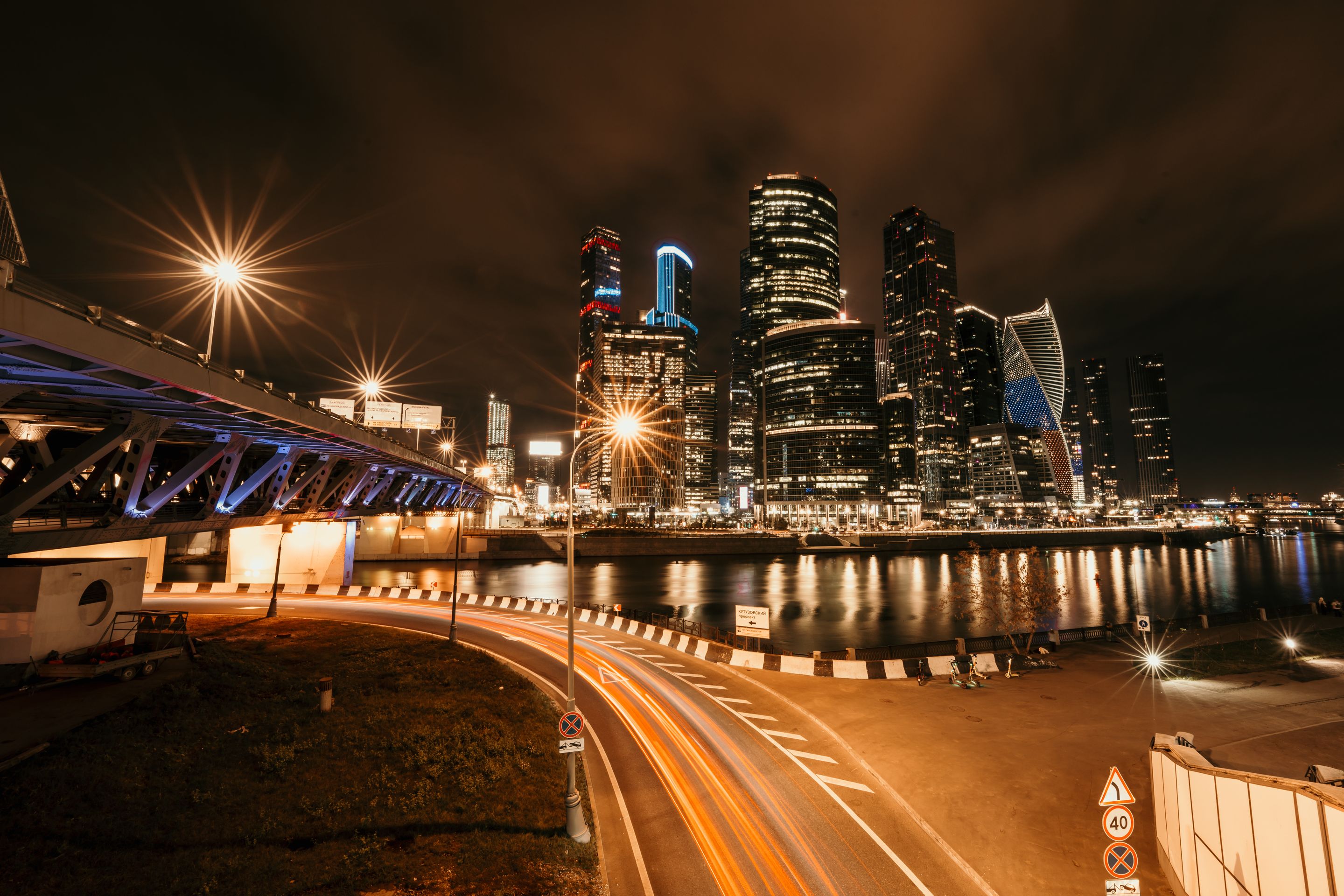 Stunning nighttime cityscape featuring illuminated skyscrapers and a bridge with glowing streetlights.