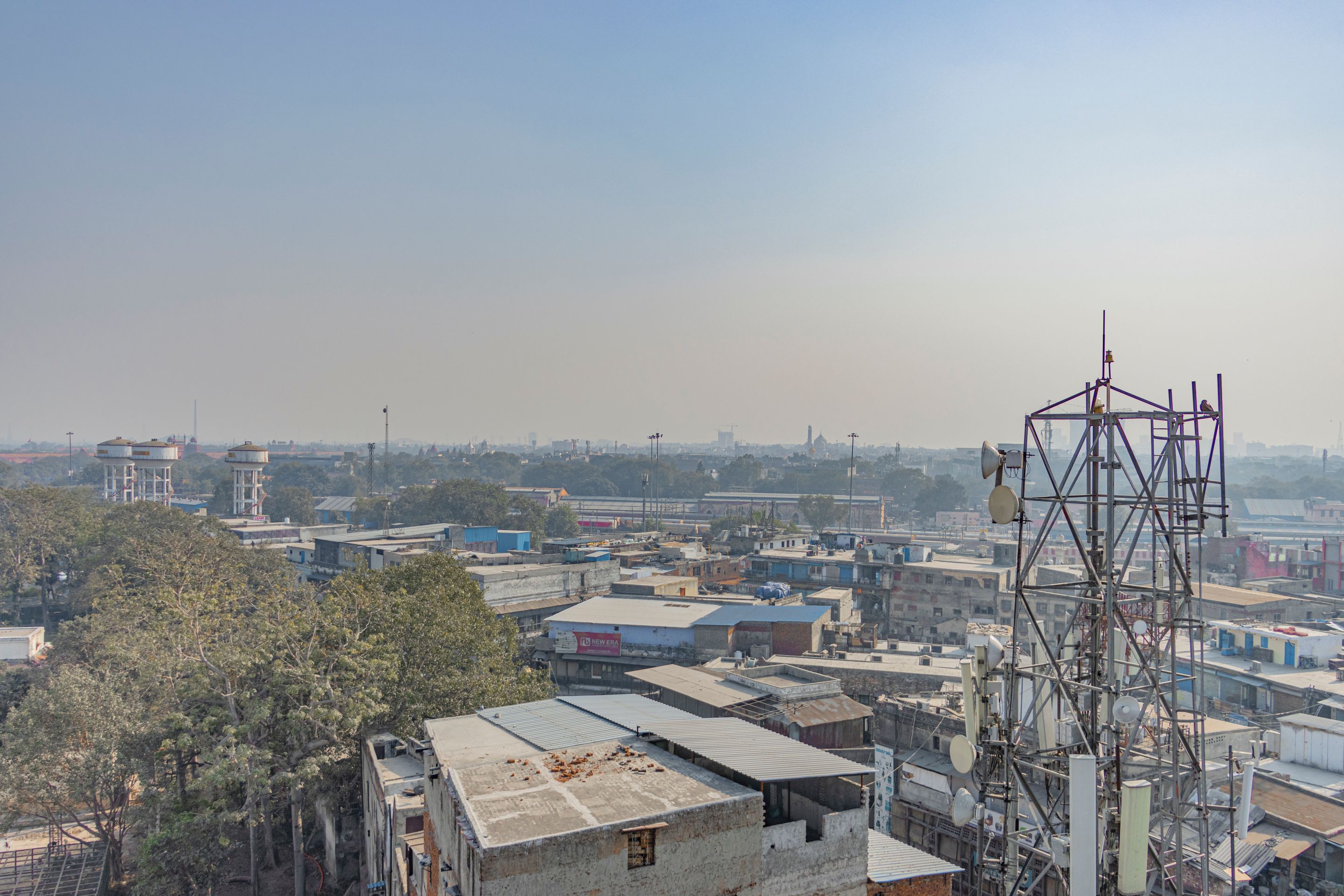 Aerial view of urban buildings and trees with a telecom tower in New Delhi, India.