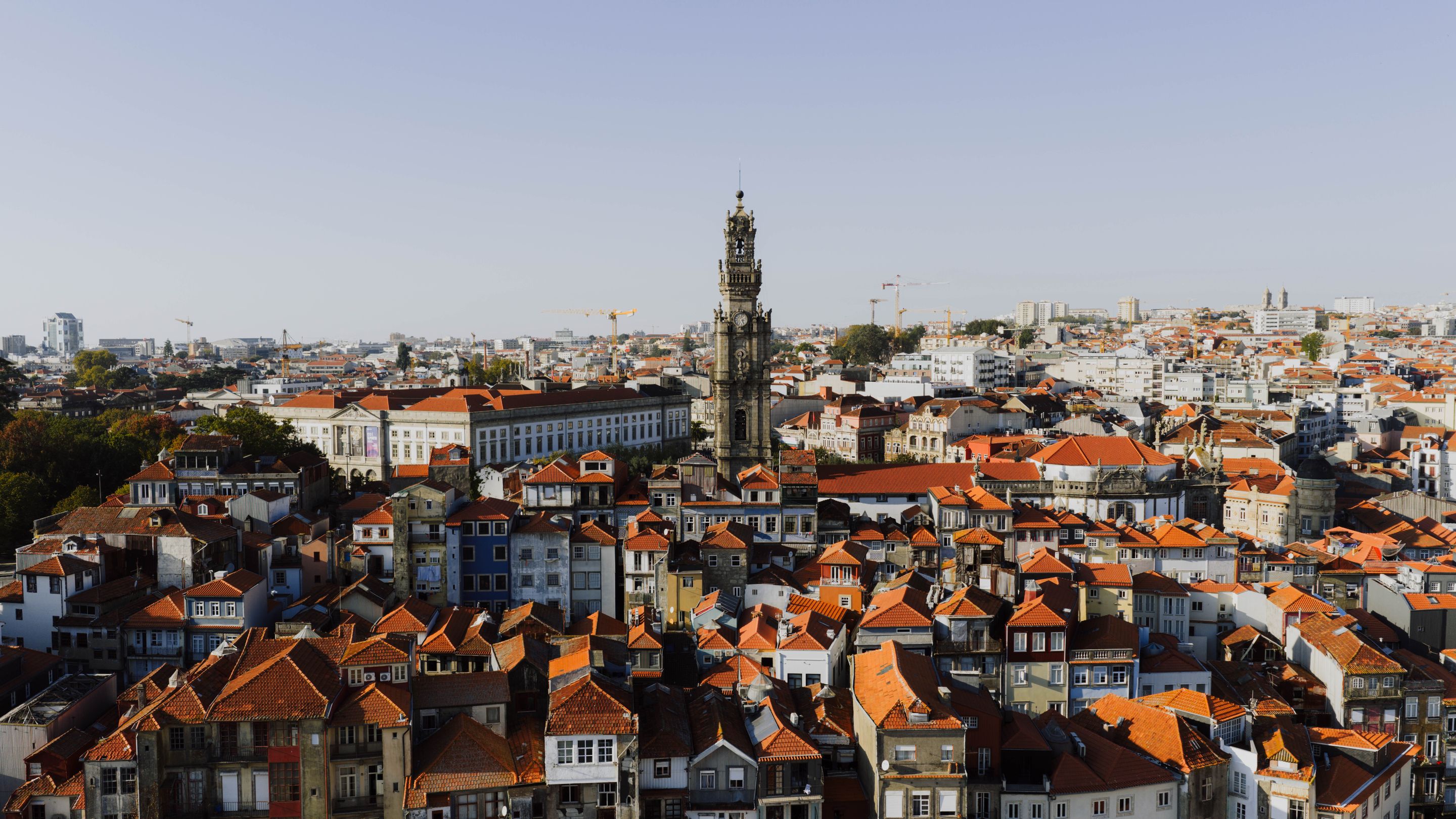 A beautiful aerial view of Porto, Portugal, highlighting the iconic Clerigos Tower at sunset.