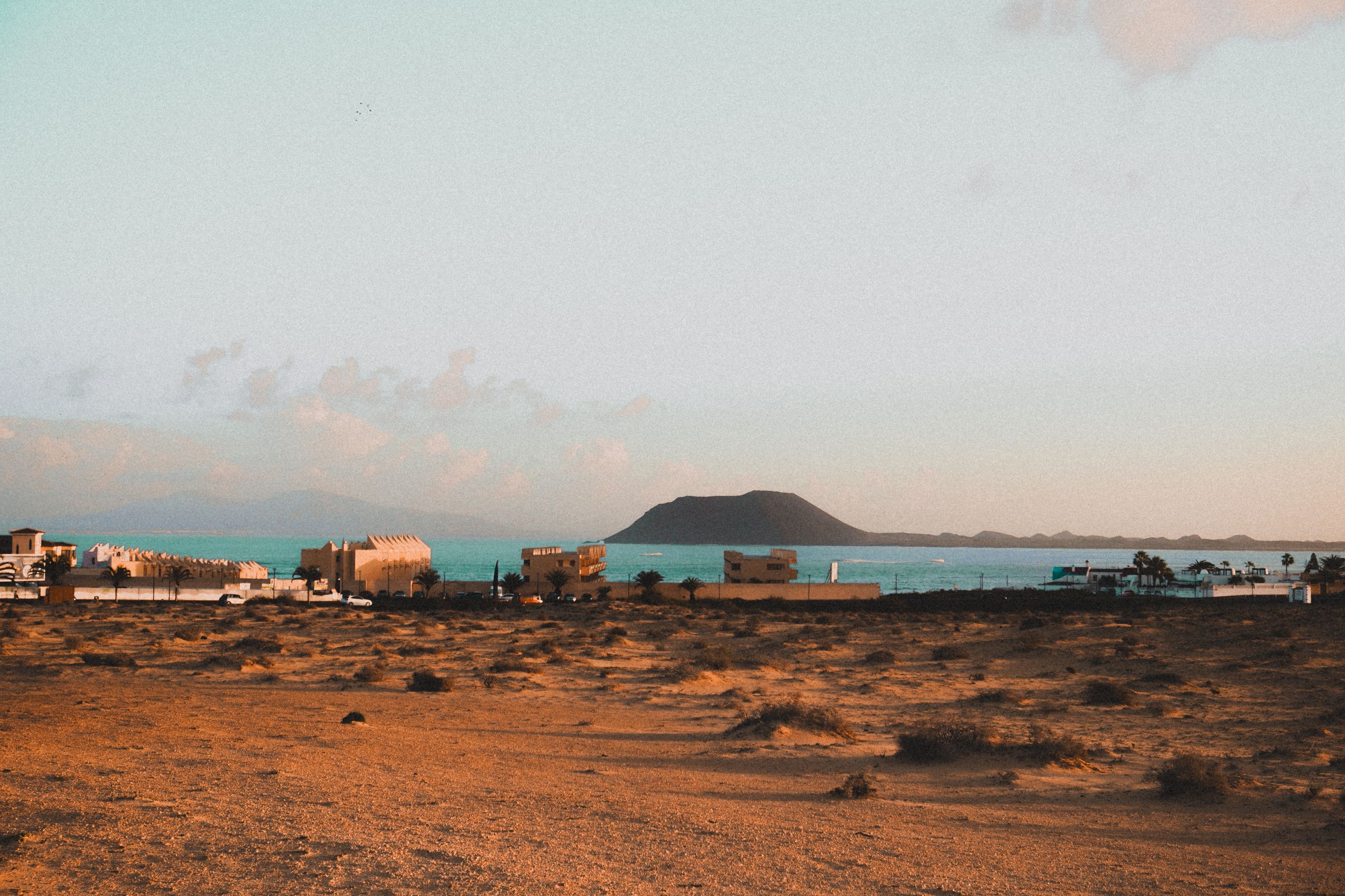 Vibrant coastal landscape with distant hills under a clear sky, suitable for travel and nature themes.