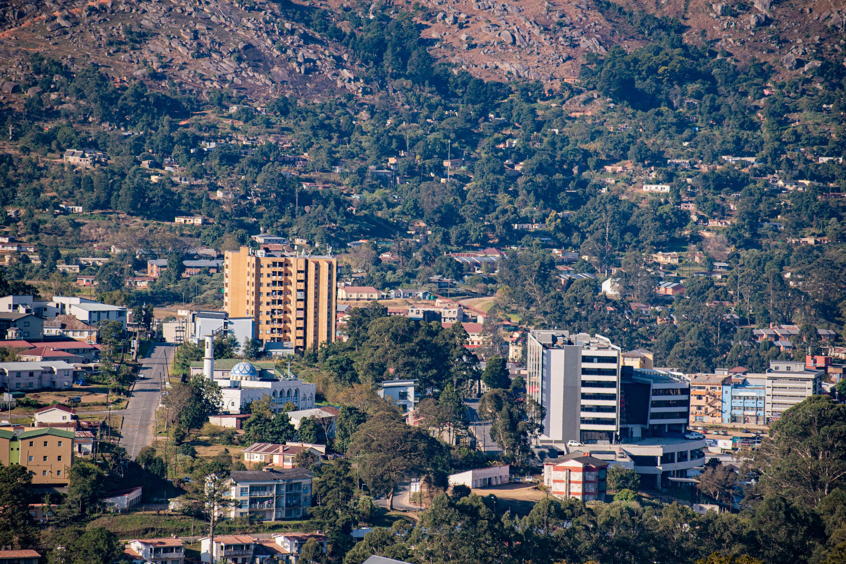 A scenic aerial view showcasing the urban landscape of Manzini, Eswatini with a mix of buildings and greenery.
