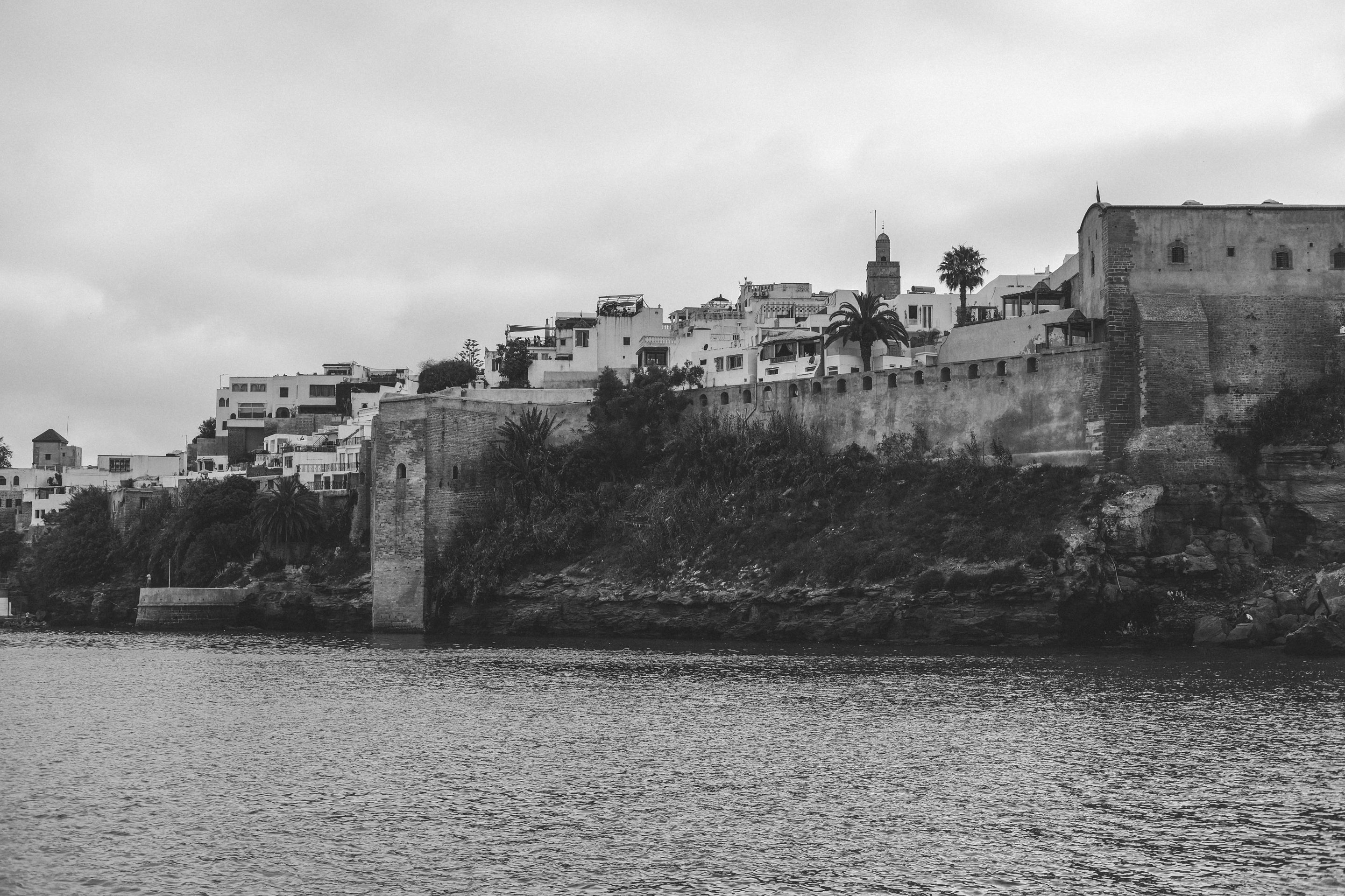 Black and white view of the historic Medina of Rabat with its fortifications near the ocean.