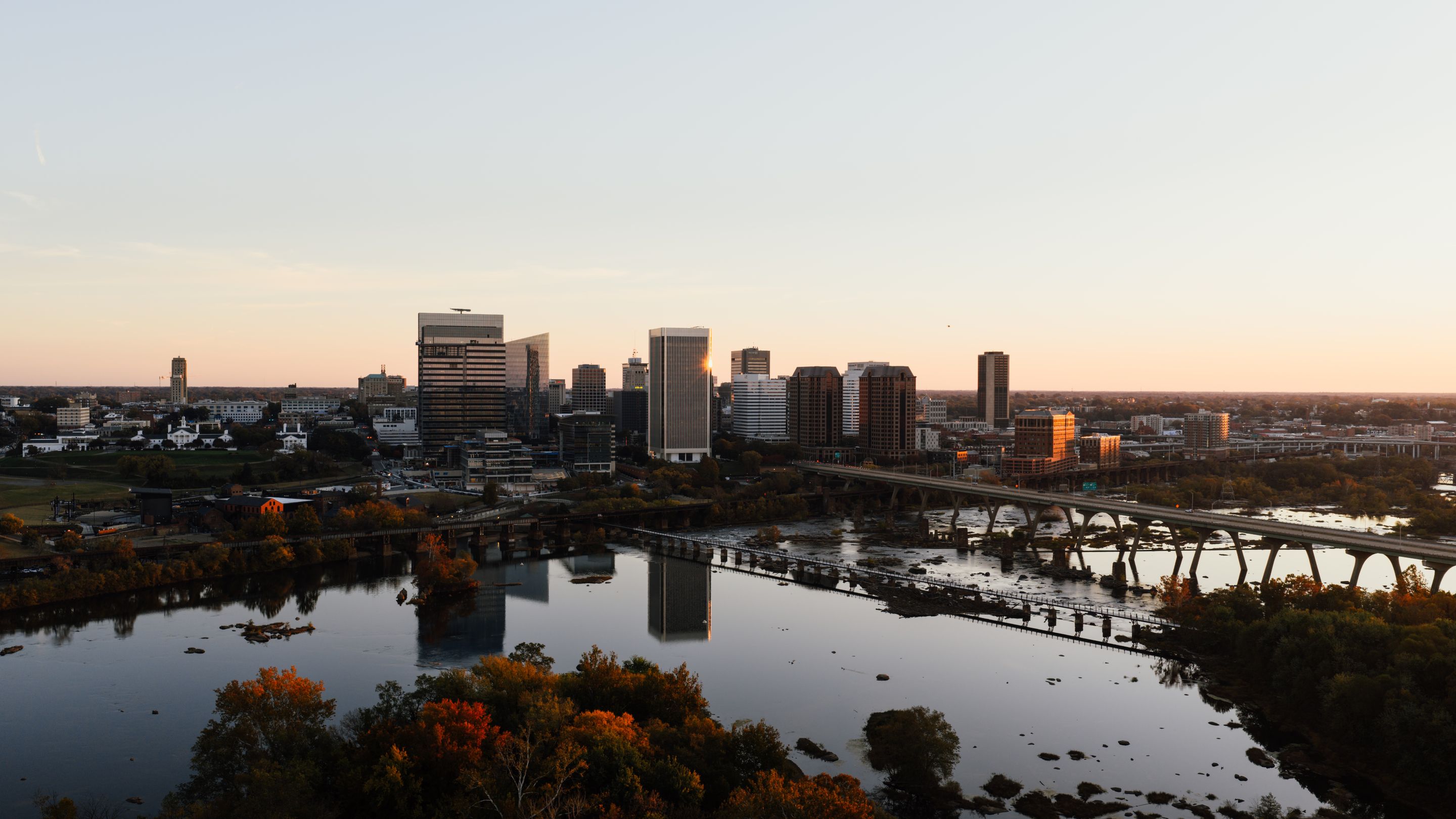Aerial view of Richmond, Virginia skyline with James River at sunset.