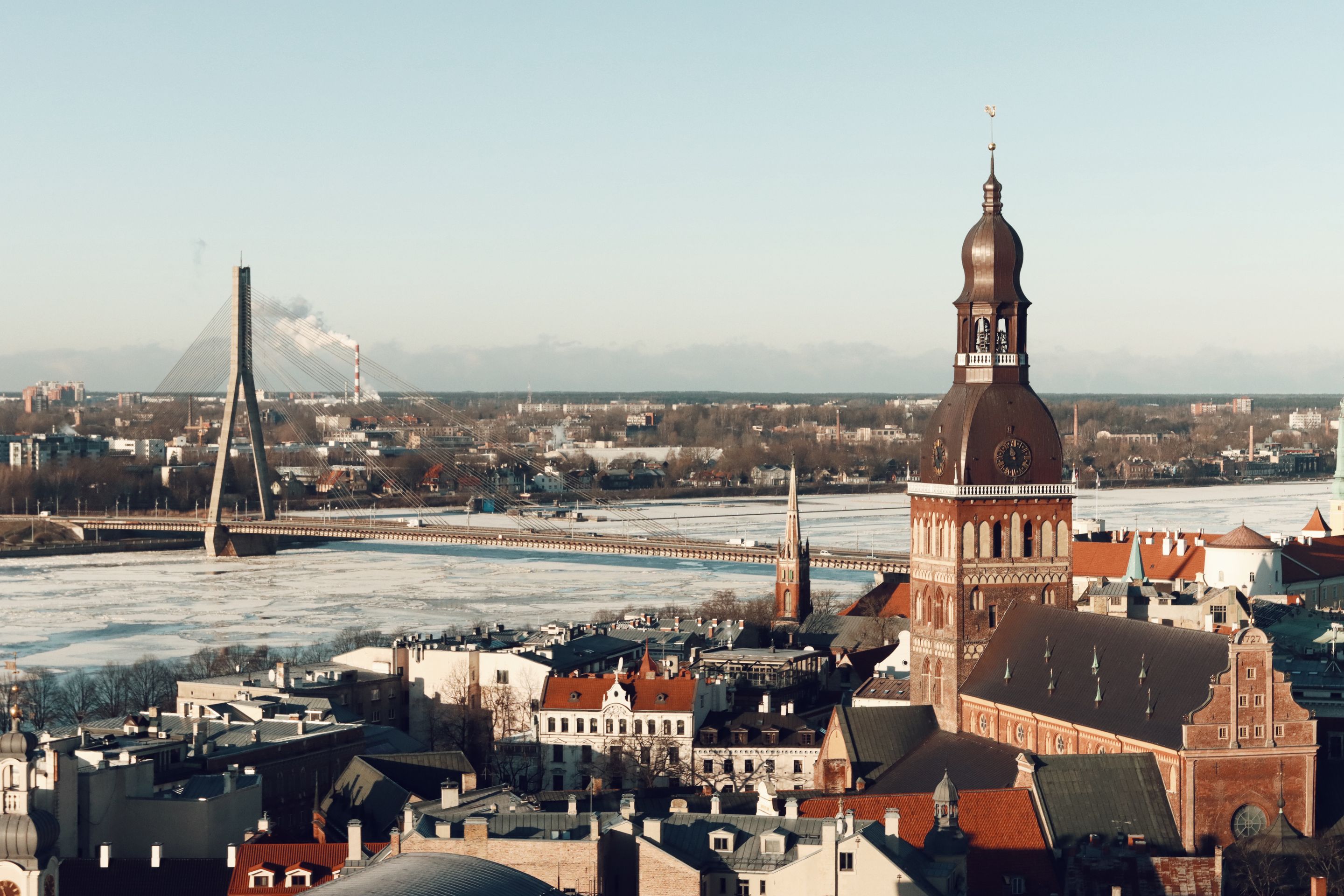 Aerial view of Riga, Latvia showcasing its iconic bridge and cathedral in winter.