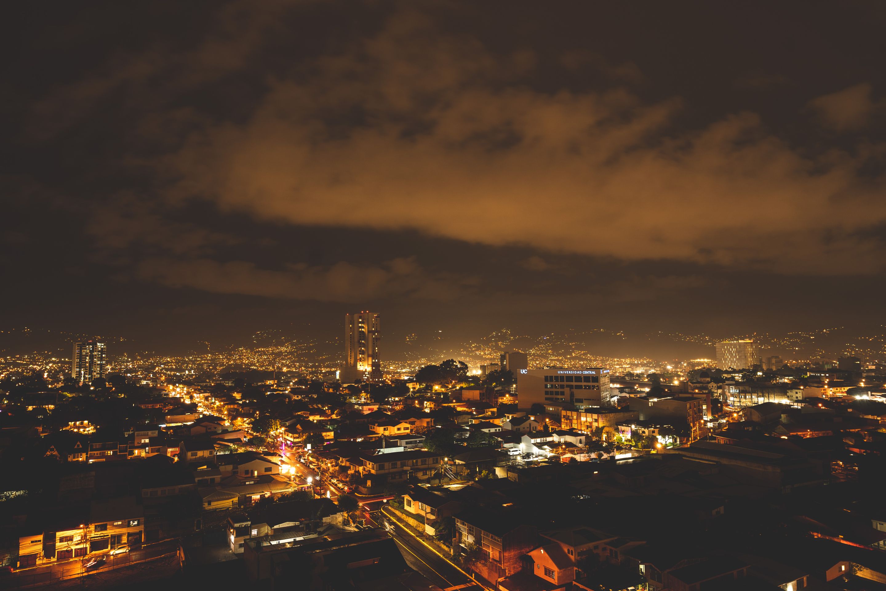 A captivating cityscape at night with glowing lights under a dramatic sky.