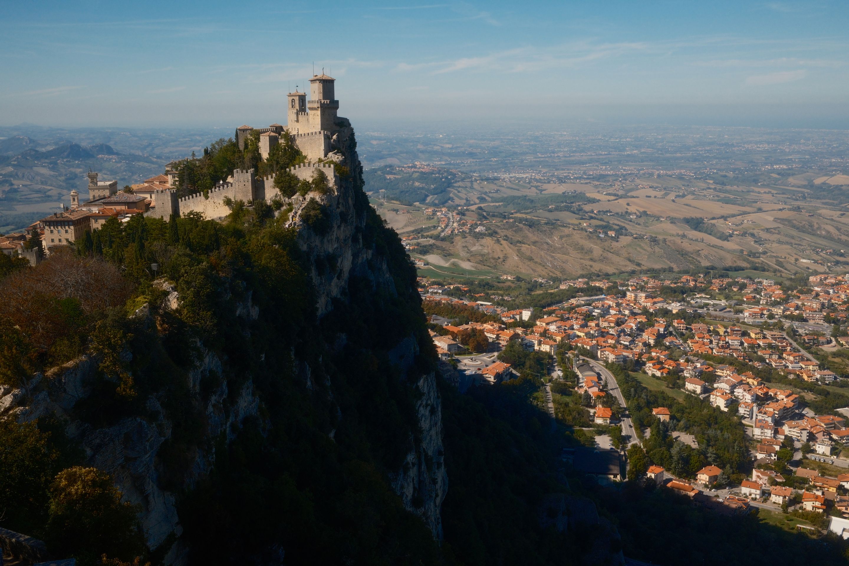 Discover San Marino's historic fortress perched dramatically atop Mount Titano overlooking the scenic landscape.