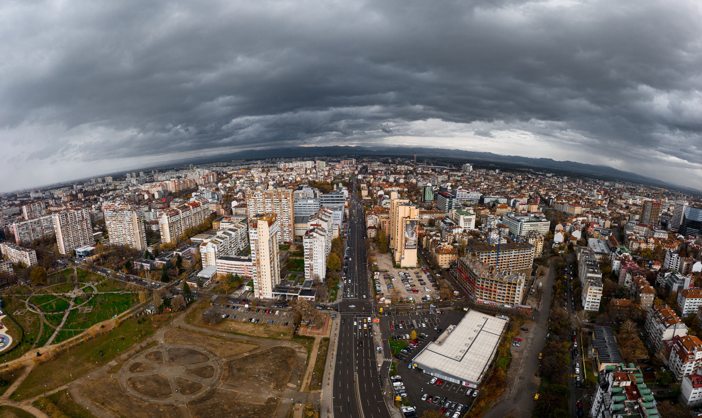 Dramatic aerial view of Sofia, Bulgaria showcasing urban architecture beneath cloudy skies.