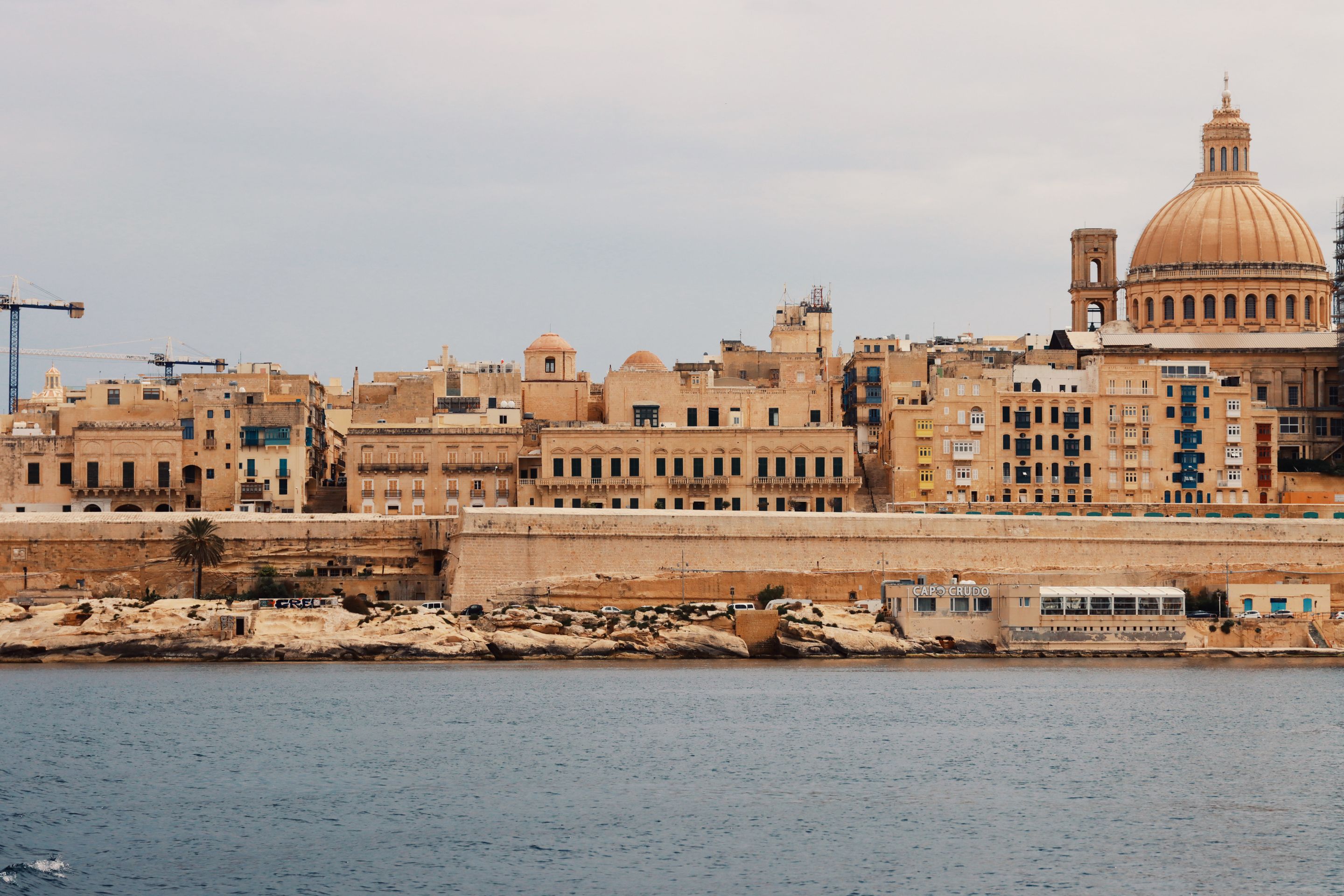 Explore Valletta's historic architecture and Mediterranean charm from a serene waterfront view.