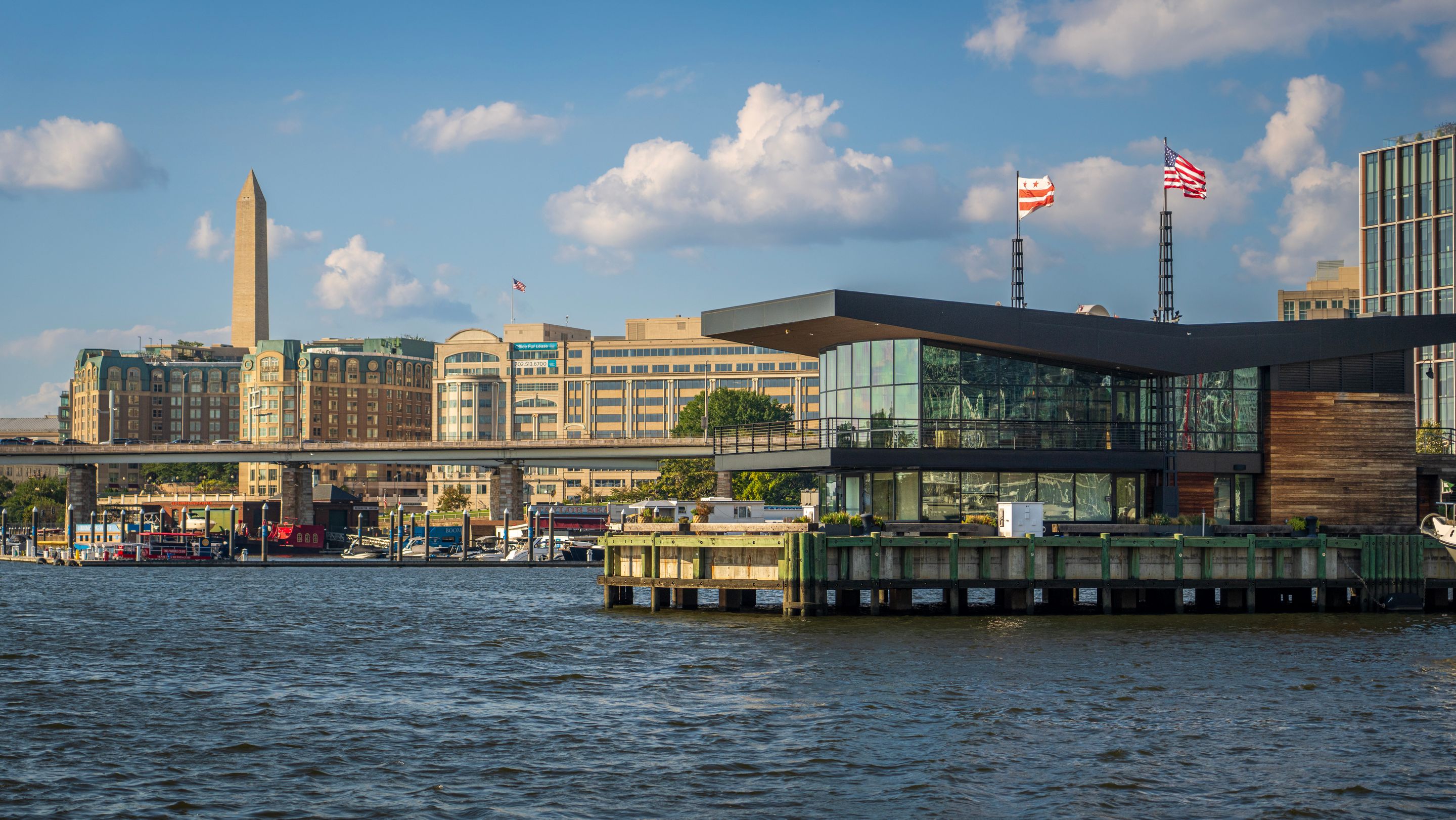 Scenic waterfront view of Washington DC featuring the Washington Monument and modern architecture.